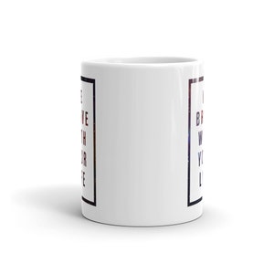 Pode incluir: Caneca de caf&eacute; de cer&acirc;mica branca com uma borda quadrada preta e o texto "Acredite com todo o seu cora&ccedil;&atilde;o" do lado esquerdo e "Seja corajoso com toda a sua vida" do lado direito. O texto est&aacute; em um degrad&ecirc; vermelho, branco e azul.