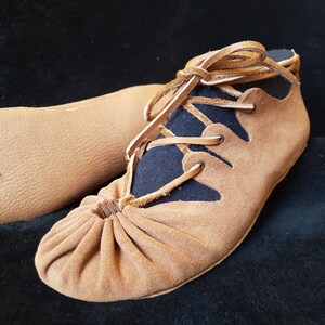 Pode incluir: Sapatos de couro castanho com forro de tecido preto e atacadores. Os sapatos t&ecirc;m uma ponta franzida e uma forma pontiaguda.