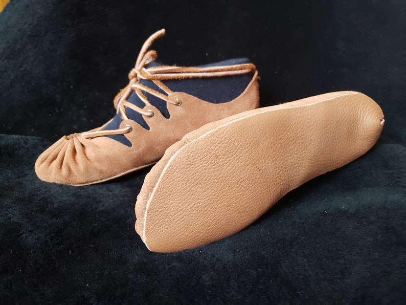Pode incluir: Um par de sapatos de couro marrom com forro de tecido preto e cadar&ccedil;os. Os sapatos t&ecirc;m uma ponta arredondada e uma sola plana. A sola &eacute; mostrada separadamente.