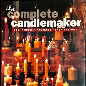 Könnte beinhalten: Ein Buch mit dem Titel "The Complete Candlemaker: Techniques, Projects, Inspirations" von Norma Coney. Der Umschlag zeigt eine Vielzahl von Kerzen in verschiedenen Formen, Größen und Farben, die alle angezündet und leuchtend sind. Die Kerzen sind auf einem Tisch mit einer Backsteinmauer im Hintergrund angeordnet.