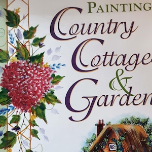 May include: A book cover with the title "Painting Country Cottages & Gardens" in purple and green script. The cover features a watercolor painting of a red hydrangea and a cottage.
