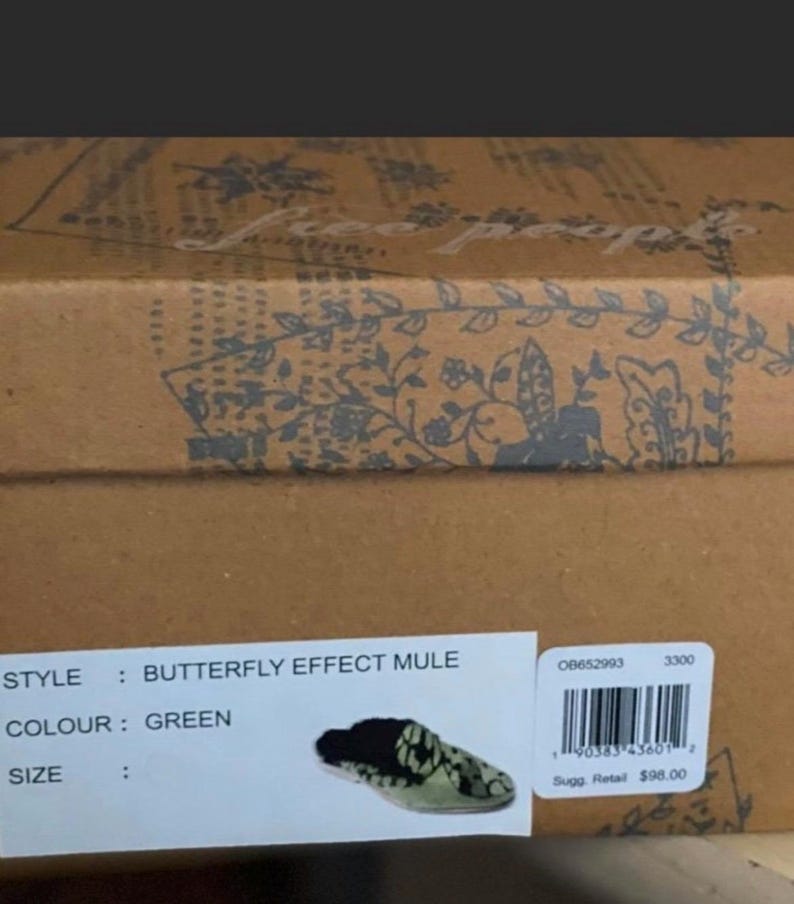 May include: A box for a pair of green butterfly effect mule shoes by Free People. The box has a floral pattern and the text "STYLE: BUTTERFLY EFFECT MULE", "COLOUR: GREEN", "SIZE", "08652993", "3300", "Sugg. Retail $98.00" is printed on the box.