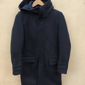 Peut inclure: Un manteau à capuche bleu marine avec une fermeture éclair et deux poches. Le manteau a une coupe décontractée et est fait d'un tissu doux et chaud.