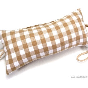 Könnte beinhalten: Ein brauner und weißer Gingham-Türstopper mit einem weißen Kordelverschluss.