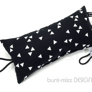 May include: Black rectangular cat toy with a white triangle pattern. It has a black cord attached to each end, and a small tag that reads "design bunt-". The toy is designed for cats.