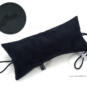May include: Black doorstop cushion with a black elastic loop and a clear plastic toggle. The cushion is made of a soft, textured fabric.