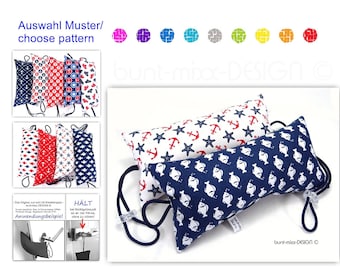 May include: Two doorstop pillows with nautical patterns. The top pillow is white with red anchors and starfish. The bottom pillow is blue with white fish. Both pillows have a blue cord.