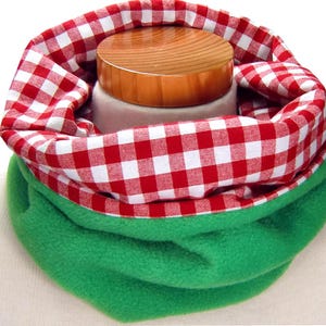 May include: Red and white gingham fabric neck warmer with a green fleece lining.