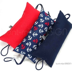 Könnte beinhalten: Drei Stoffkissen mit nautischem Thema. Die Kissen sind rot, blau mit weißen Ankern und einfarbig blau. Die Kissen haben einen Kordelverschluss und sind miteinander verbunden.