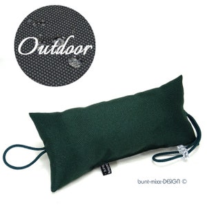 以下が含まれることがあります： 黒地に「bunt-mix-DESIGN ©」と記された黒いラベルとループハンドルが付いた濃い緑色のドアストッパーのクッション。クッションは、黒い布地に水滴が落ちている画像のように、撥水加工が施された生地で作られています。