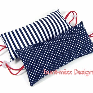 May include: Two doorstop cushions with red ties. One cushion is navy blue with white polka dots and the other is navy blue and white striped. The cushions have the text "bunt-mix Design ©" on the bottom.