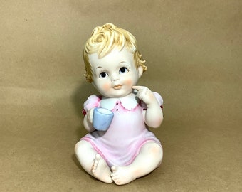 Vintage ceramic piano baby girl figurine holding a cup,   Baby shower ceramic figurine accessory