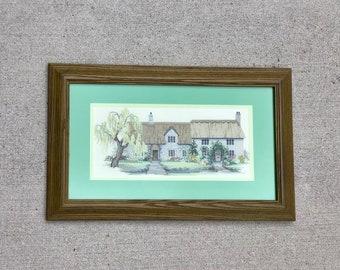 Large completed framed matted needlepoint picture of a cottage garden home.