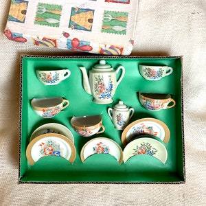 Puede incluir: Un juego de té de porcelana vintage con diseños florales. El juego incluye una tetera, una jarra de crema, un azucarero y cuatro tazas de té y platillos.