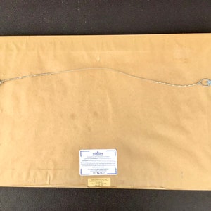 K&ouml;nnte beinhalten: Die R&uuml;ckseite eines gerahmten Drucks mit einem Echtheitszertifikat. Das Zertifikat stammt von "The Bradford Exchange" und hat einen blauen Rand. Der Druck h&auml;ngt an einer braunen Wand.