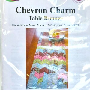 May include: A sewing pattern package for a Chevron Charm table runner by Trippity Do-Dahs. The cover features a colorful, multi-patterned chevron table runner design, text including 'Use with From Marti Michell 2 1/2 inch Strippers', and product #8059.
