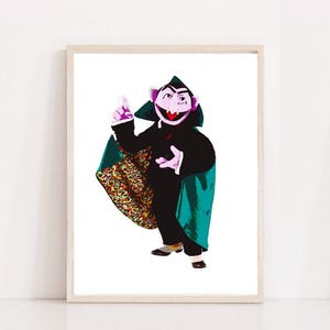 May include: A purple and pink Sesame Street character dressed as a vampire with a green cape and a colorful patterned cape. The character is holding a finger up in the air and has a mischievous expression on its face.