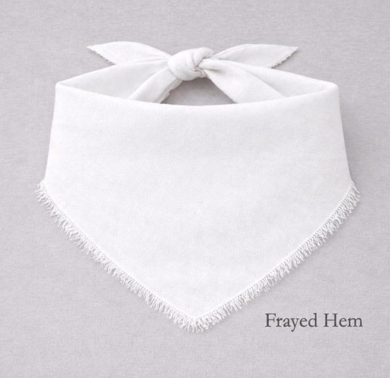 A white bandana with fringed edges is displayed against a gray background.
