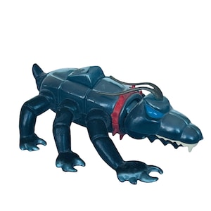 May include: A blue plastic toy creature with red and black accents. The creature has a long snout with sharp teeth and four legs. It has a segmented body and a pair of antennae.