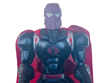 May include: A black and red action figure of a superhero wearing a red cape and a black helmet with a cobra symbol on the chest.