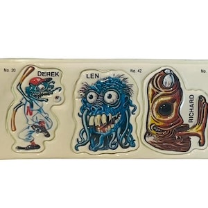 May include: A sheet of vintage 1979 Topps Monster Stickers featuring three different monster characters. The characters are Derek, Len, and Richard. The stickers are numbered 20, 42, and 29. The text "Collect all 68 Monstickers" is printed on the sheet.