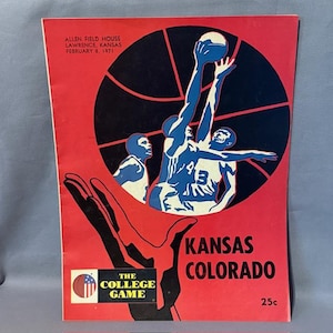Könnte beinhalten: Vintage Basketball-Spielprogramm mit rotem Hintergrund. Das Cover zeigt eine schwarze Basketballgrafik mit blau-weißen Illustrationen von Spielern. Der Text enthält "Allen Field House, Lawrence, Kansas, February 8, 1971", "Kansas Colorado" und "The College Game".