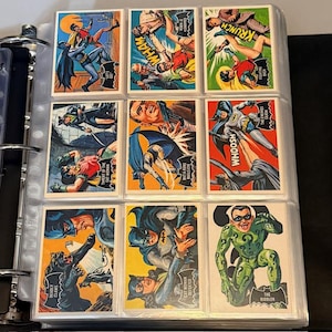 Könnte beinhalten: Ein Ordner mit Batman-Sammelkarten im Vintage-Stil. Die Karten zeigen farbenfrohe Comic-Illustrationen von Batman, Robin, Catwoman und dem Riddler. Aktionswörter wie "WHAM" und "WHOOSH" werden in Sprechblasen angezeigt.