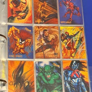 Könnte beinhalten: Neun Spider-Man-Sammelkarten in einem Ordner. Die Karten zeigen lebendige Illustrationen von Charakteren, darunter "Chance", "Demogoblin" und "Doppelganger". Die Karten befinden sich in einer transparenten Kunststoffhülle.