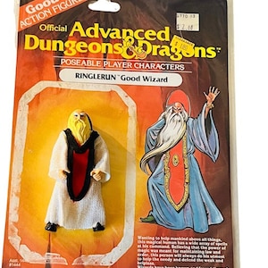 May include: A plastic action figure of a wizard from the Dungeons & Dragons game. The figure is wearing a white robe with a red sash and has a long white beard. The figure is posed with his arms outstretched. The packaging is yellow and orange with the Dungeons & Dragons logo and the words "Ringlerun Good Wizard".