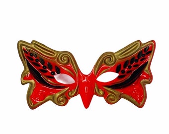 May include: A red and gold masquerade mask with black accents and a butterfly design.