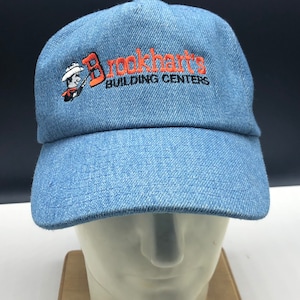 May include: A blue denim baseball cap with an orange embroidered logo that says "Brookhart's Building Centers".