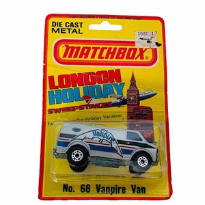 May include: A Matchbox London Holiday Sweepstakes die-cast metal toy car. The car is a white and blue van with a red stripe and a bat logo. The van is labeled "No. 68 Vampire Van".