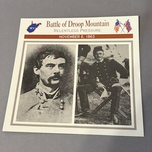 May include: A printed card featuring two black and white portraits of men in military uniforms. The card's header reads "Battle of Droop Mountain" with the text "Relentless Pressure" and "November 6, 1863". Flags are also displayed.
