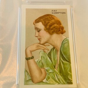 K&ouml;nnte beinhalten: Eine Vintage-Sammelkarte mit einem Schwarzwei&szlig;portr&auml;t von Fay Compton, einer Schauspielerin. Die Karte hat einen wei&szlig;en Hintergrund mit schwarzem Text, der "Fay Compton" lautet.