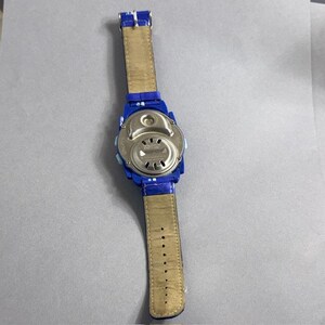 Puede incluir: Un reloj digital azul con una correa de cuero marr&oacute;n claro. La parte trasera del reloj es plateada. La correa es de color marr&oacute;n claro con una serie de agujeros para el ajuste.
