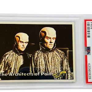 Puede incluir: Una tarjeta de intercambio vintage de Star Trek con un primer plano de dos personajes alienígenas, conocidos como "The Architects of Pain", de la serie de 1976. La tarjeta está en una caja de plástico protectora.