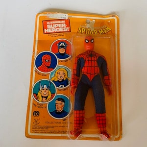 May include: A vintage action figure of Spider-Man in his red and blue suit with a spider web design. The figure is packaged in a plastic blister pack with a yellow and orange cardboard backing. The packaging features images of other superheroes, including Captain America, Spider-Man, Thor, and the Incredible Hulk. The text on the packaging reads "Les Extraordinaires Super-Heroes!" and "Spider-Man".