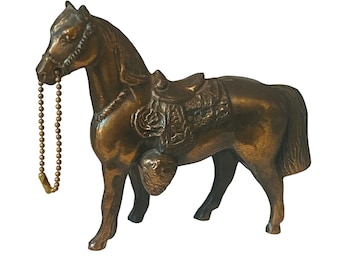 May include: A bronze horse figurine with a saddle and a gold chain. The horse is standing on a white background.