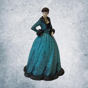 May include: A teal figurine of a woman in a long gown and jacket. The dress has a detailed pattern and a dark trim. The jacket has fur trim. The woman is wearing a beret.