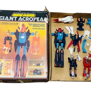 May include: A vintage toy robot set called "Giant Acroyear" from the Micronautse line. The box shows a blue and red robot with interchangeable parts, including a spaceship and other accessories.
