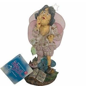 Può includere: Una statuina stravagante di una fata con ali rosa, che tiene in mano una bacchetta e una piccola borsa. La fata indossa un abito chiaro con accenti glitterati. La base presenta libri e fiori. Un'etichetta recita "Magical Dreamers."