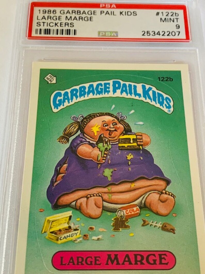 Puede incluir: Una tarjeta de intercambio de Garbage Pail Kids con un personaje de dibujos animados llamado Large Marge. Es un beb&eacute; grande y regordete con un vestido morado y la cara sucia. Est&aacute; sentada en un inodoro con una lata de cola y una caja de caramelos cerca. La tarjeta es verde y tiene el texto "Garbage Pail Kids" y "Large Marge" en ella.