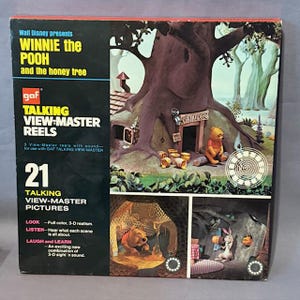 Könnte beinhalten: Ein Vintage View-Master-Rollen-Set mit Winnie the Pooh und dem Honigbaum. Die Box zeigt den Titel, das GAF-Logo und die Worte "Talking View-Master Reels". Die Box zeigt auch 3D-Bilder von Winnie the Pooh.