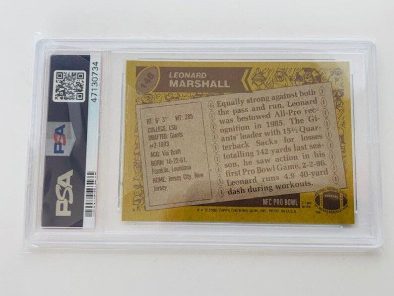Op de afbeelding: Een vintage Topps voetbalkaart uit 1985 met Leonard Marshall, een voormalige NFL-defensive end. De kaart is in uitstekende staat en toont een foto van Marshall in zijn New York Giants-uniform. De kaart bevat ook Marshalls statistieken en een korte biografie.