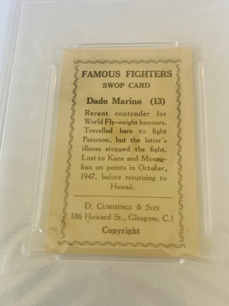 May include: A vintage trading card featuring a black and white photo of a boxer. The card is titled "Famous Fighters Swop Card" and features the text "Dado Marino (13)" and a biography of the boxer.