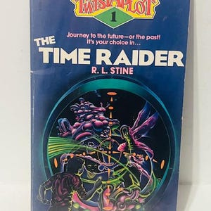 May include: A blue book cover with the title "The Time Raider" and the author "R.L. Stine". The book is part of the "Twistaplot" series and features a colorful illustration of a futuristic scene with a person in the foreground.