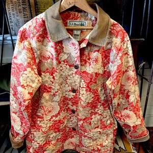 May include: A handmade, wooden cutting board with a natural finish. The board features a live edge on one side and a smooth, rectangular shape. It is approximately 18 inches long and 12 inches wide.