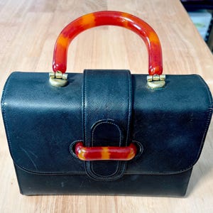 Cartera vintage Etra de cuero negro de mediados de siglo con asa de baquelita, en excelente estado