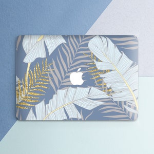May include: A blue laptop skin with a tropical leaf design. The leaves are light blue and white with gold glitter accents.
