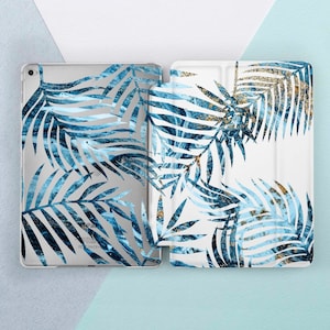 May include: A white iPad case with a blue and gold tropical leaf pattern. The case is made of a clear plastic material and has a fold-over flap.